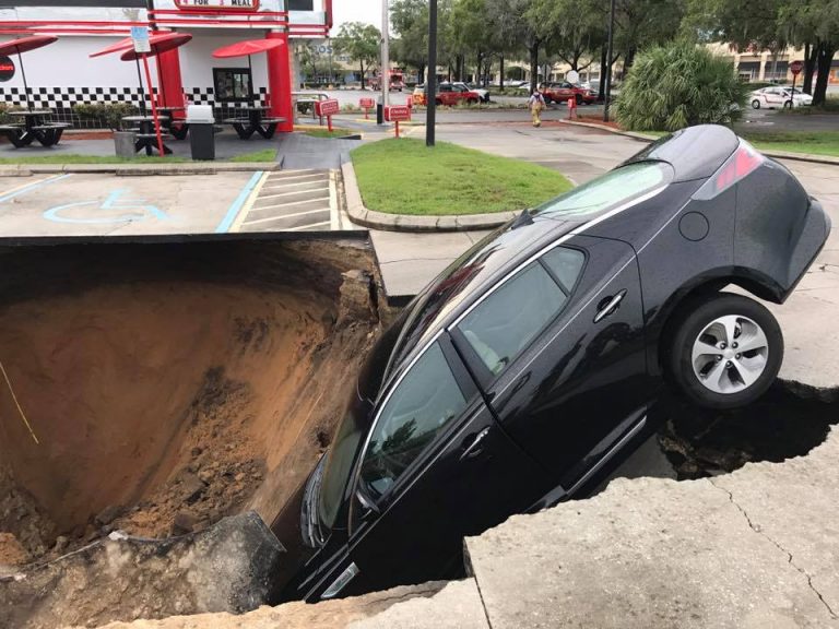 Massive sinkhole swallows car at Checkers restaurant in Ocala