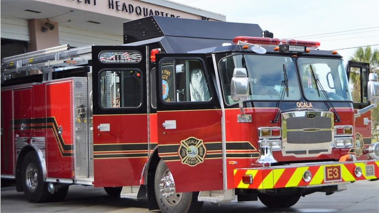 Ocala firefighters battle vehicle fire threatening nearby residence