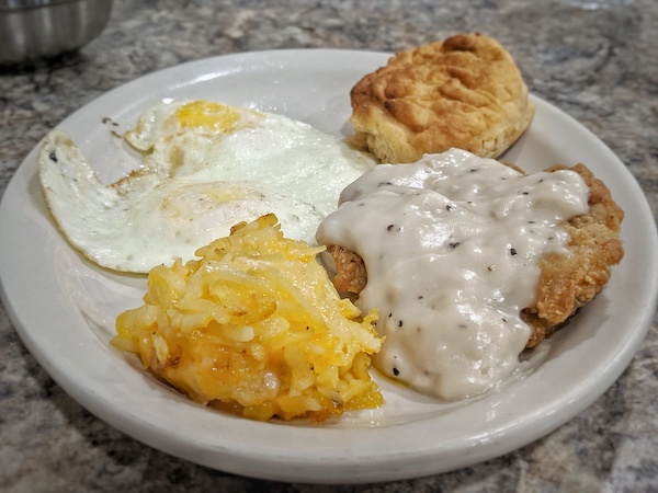 Country Fried Steak, eggs, biscuit, and hash brown casserole at Scrambles in Ocala, FL