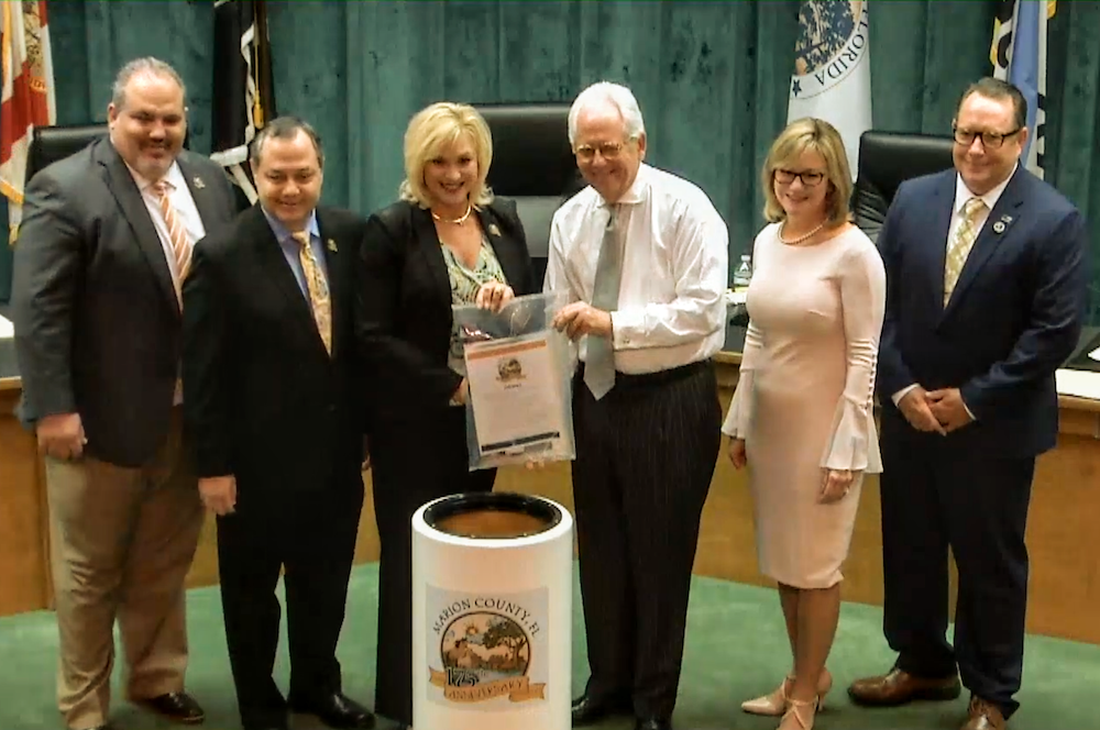 Mayor Kent Guinn of Ocala places items into the Marion County time capsule