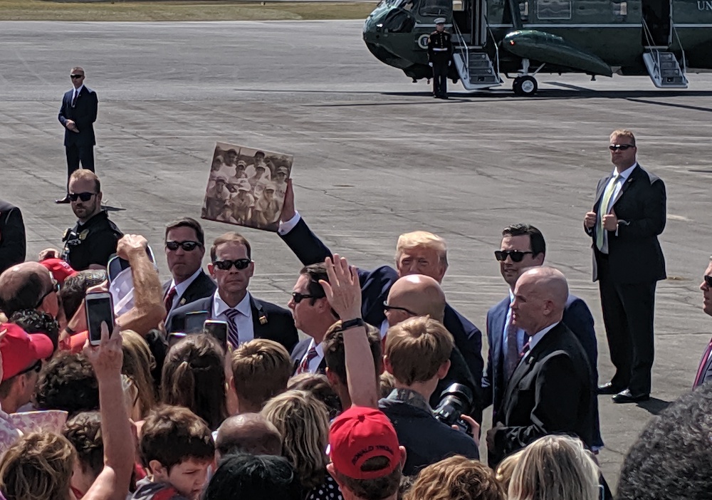 President Donald J Trump holds up a canvas print of himself as a little league player