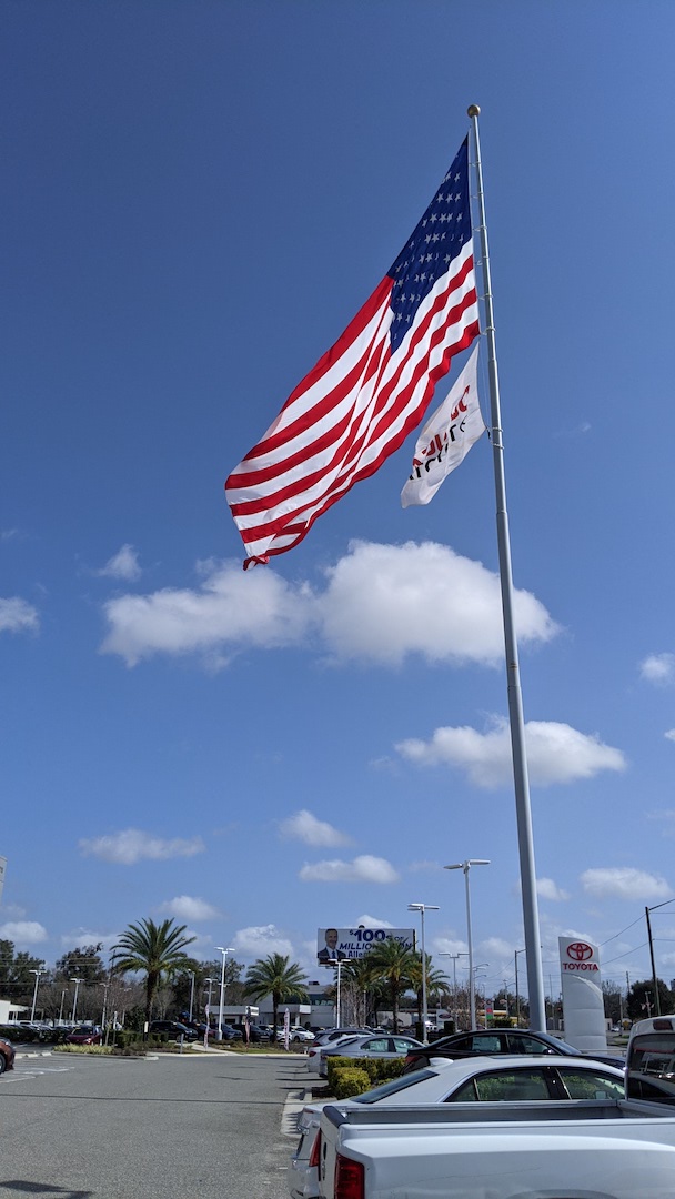 American Flag On Windy Day Over DeLuca Toyota In Ocala