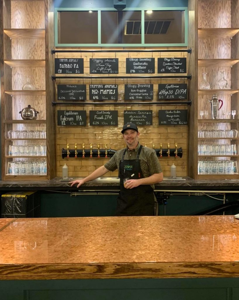 Travis Arenburg in front of the taps at The Juniper General Store Travis Arenburg in front of the taps at The Juniper General Store