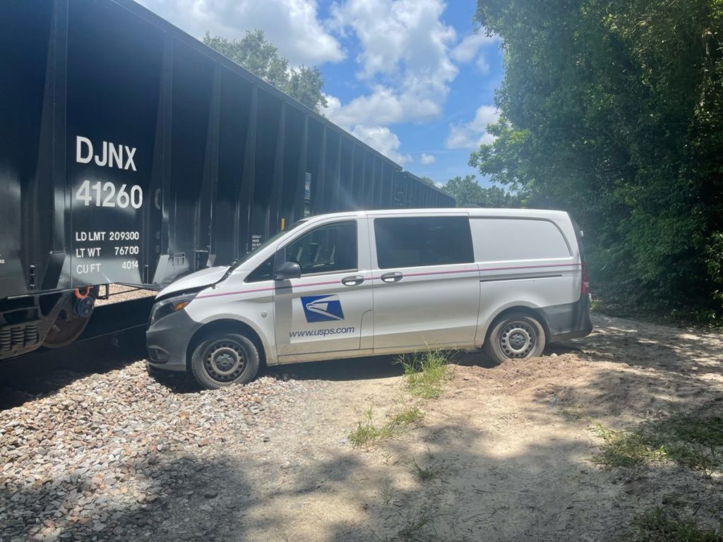 A USPS vehicle was stock in sand and struck by a passing train
