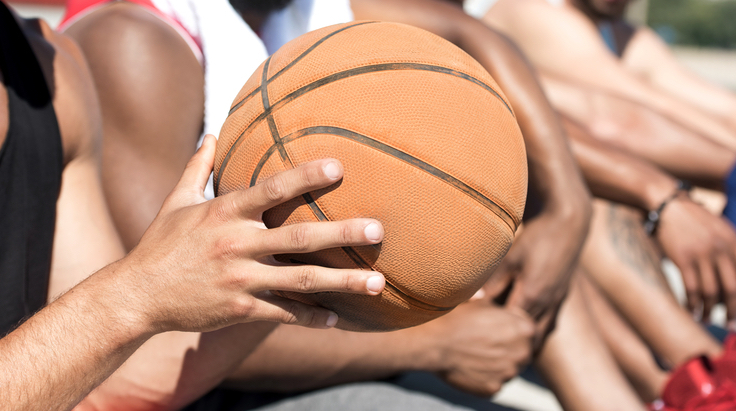 Basketball being held by hands