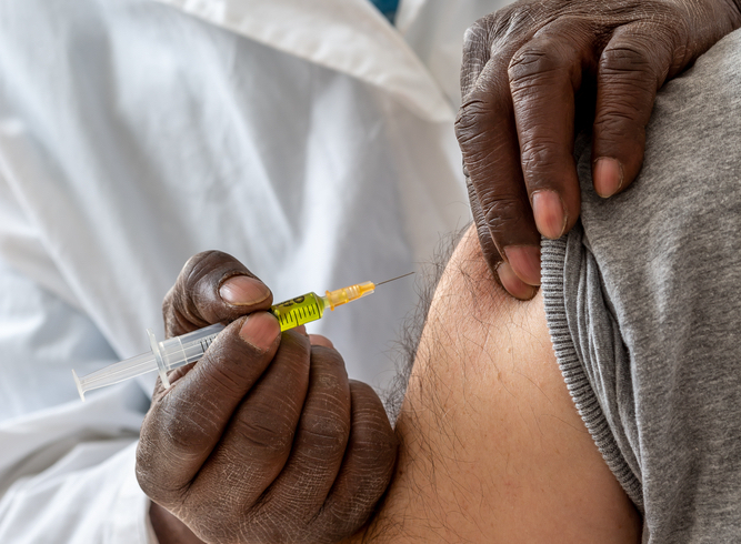 Doctor administering vaccine shot to patient
