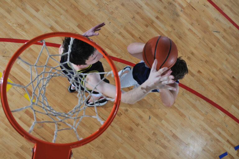 Two men playing basketball under the hoop