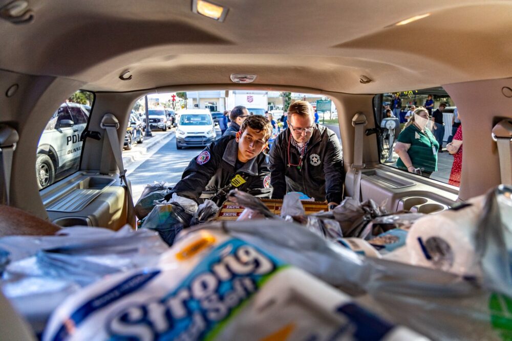 Bring the Harvest Home 2022 officers grabbing donated items from vehicle photo courtesy of Marion County