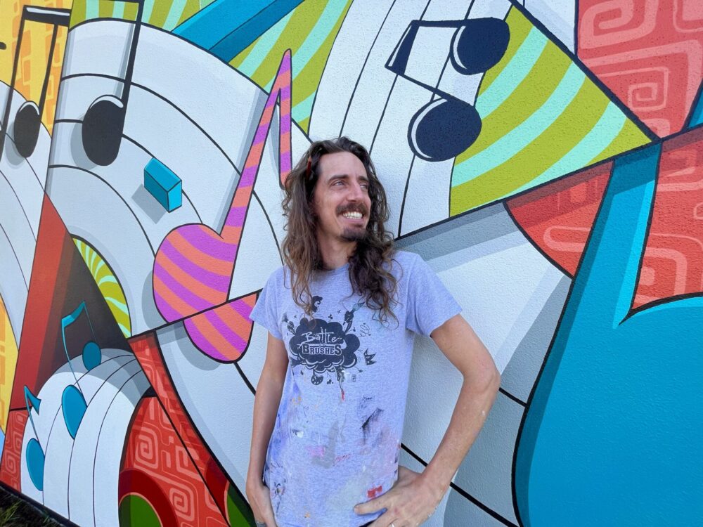 Justin Alsedek in front of mural Reilly Arts Center 4