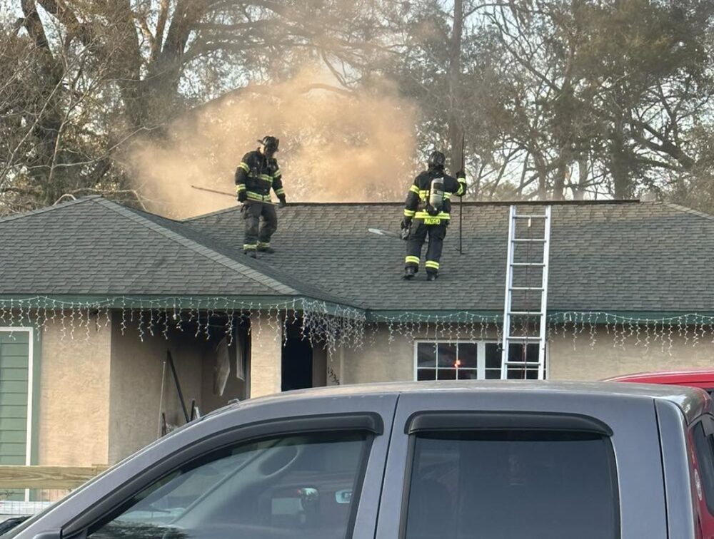 Marion County Fire Rescue NE Ocala home fire on February 20 2023 - two firefighters on roof with smoke