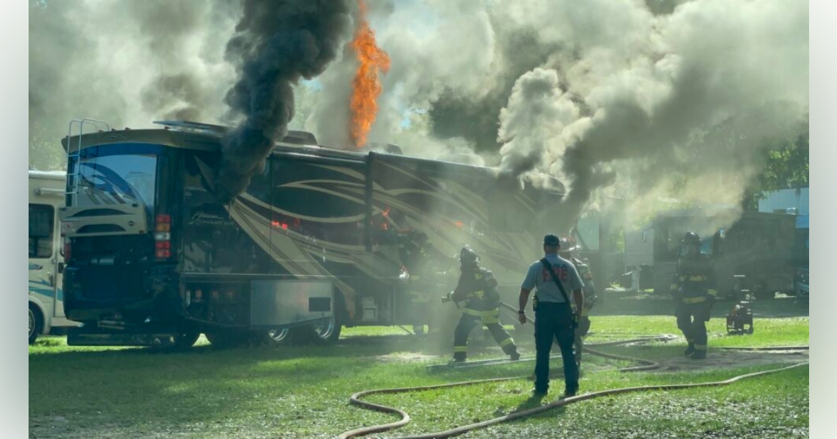 Ocala firefighters battle RV fire in business parking lot on March 16, 2023 - smoke and fire rising from RV
