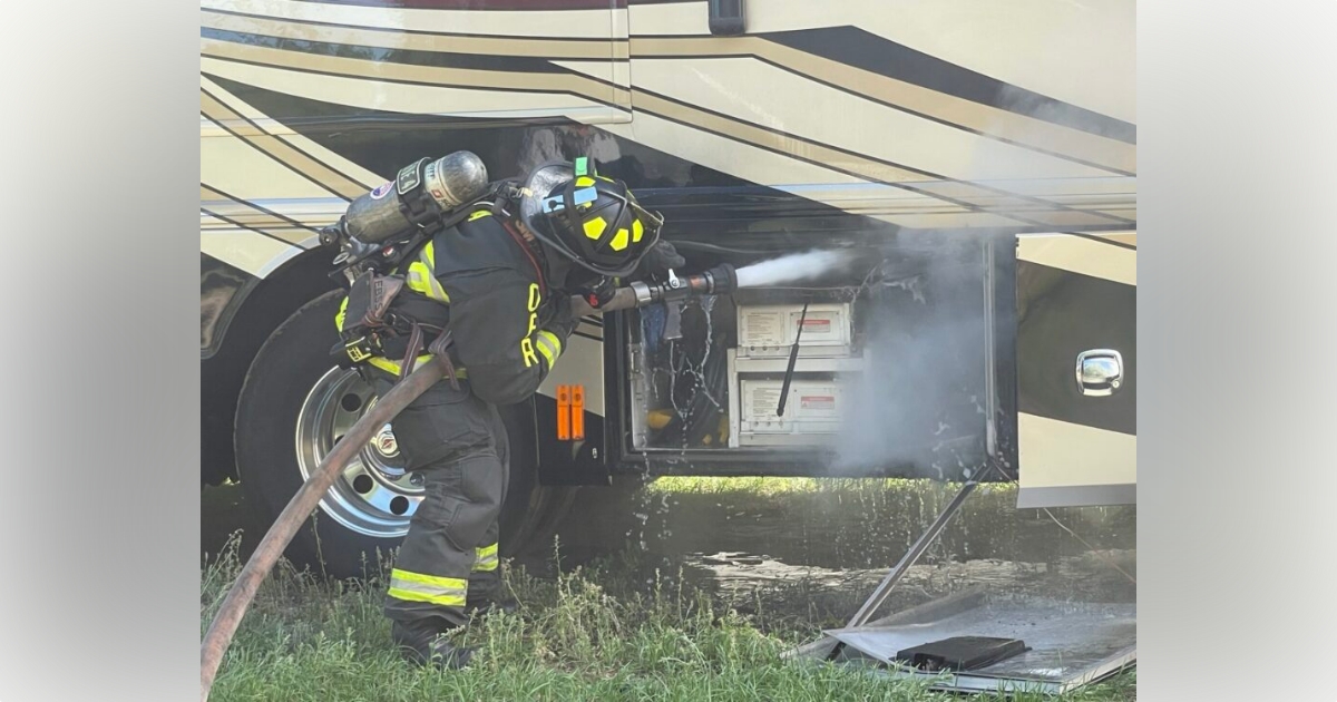 Ocala firefighters battle RV fire in business parking lot on March 16, 2023 - firefighter dousing battery with water