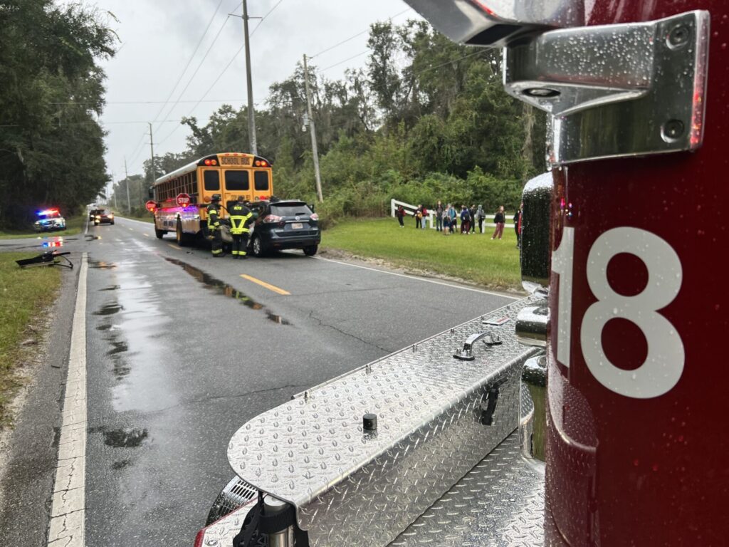 Vehicle rear ends school bus in Marion County on November 16, 2023 (photo by MCFR) - children standing outside bus