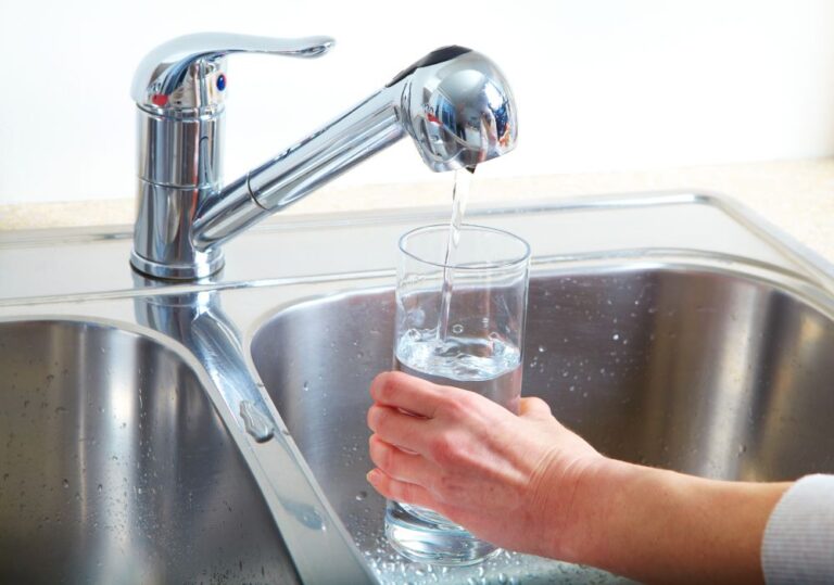 glass of water being filled at sink (stock image)