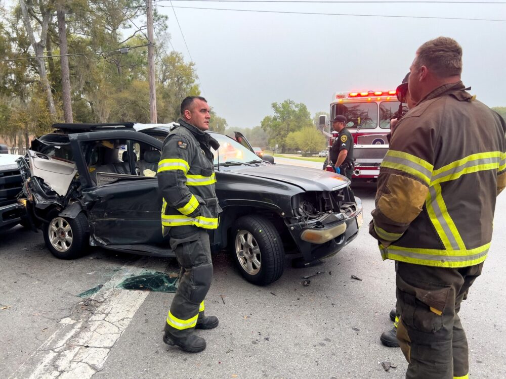 Two vehicle crash in northeast Ocala on March 5, 2024, sends three to hospital firefighters standing near SUV involved in crash (photo by MCFR)