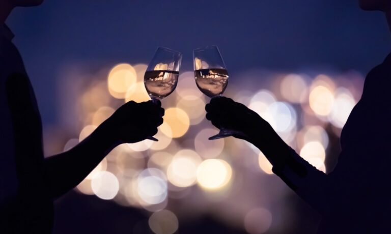 Two people clinking wine glasses on date night