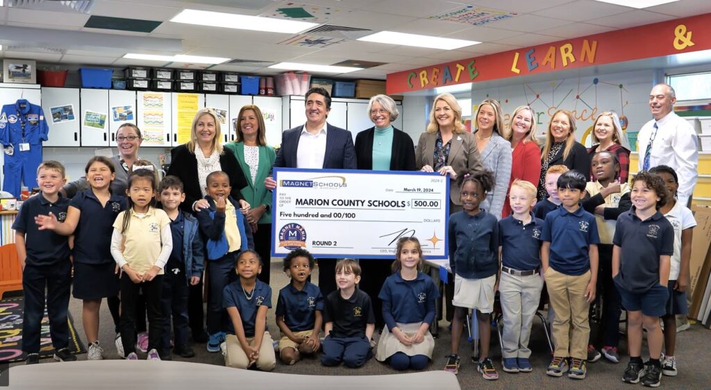 Marion County Public School officials and students accept $500 towards a new, AI-magnet program. 