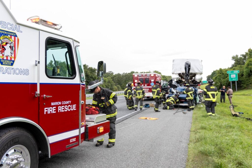 Crews work to remove a car from the back of a stopped semi truck on Sunday, June 30