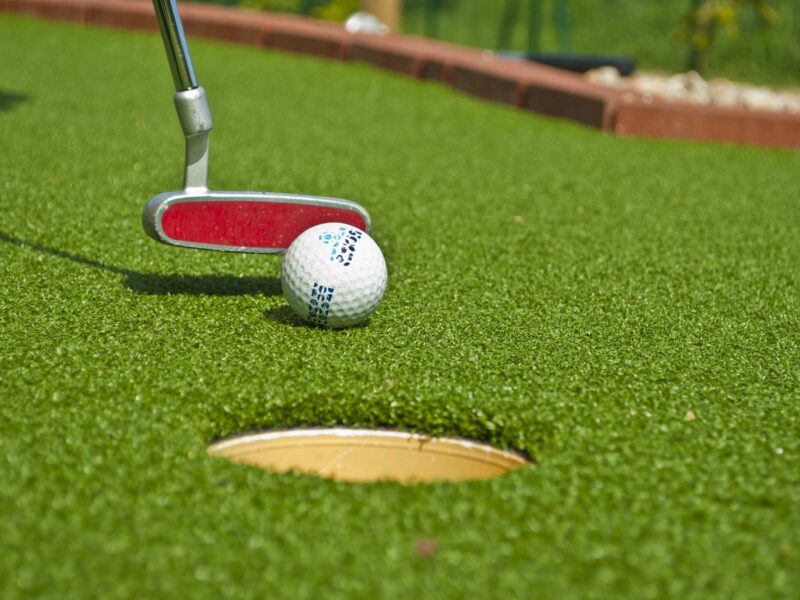 Golf ball being hit into golf hole