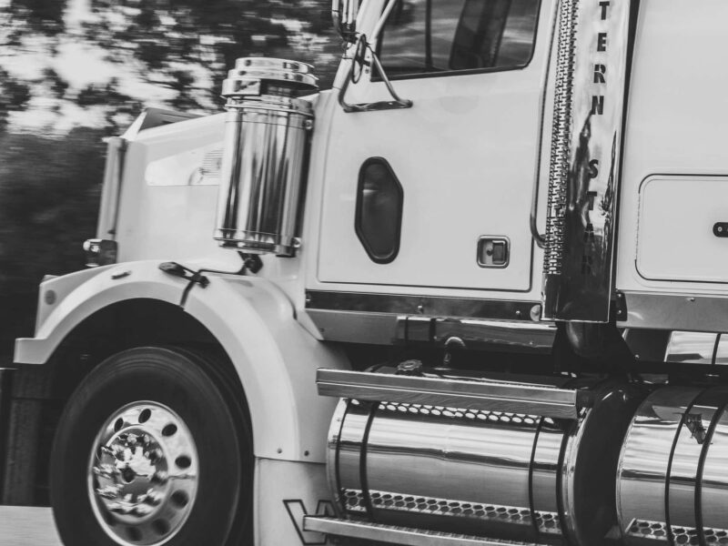 Semi-truck tractor-trailer driving down road