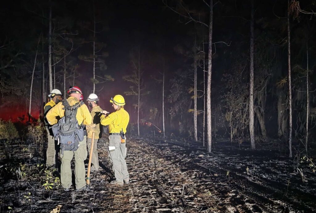 Firefighters worked into the night to contain the fire, which expanded to over 100 acres.