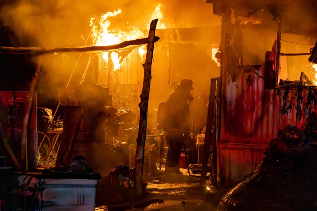 A firefighter walks through the burned mobile home in Silver Springs on May 19, 2025.