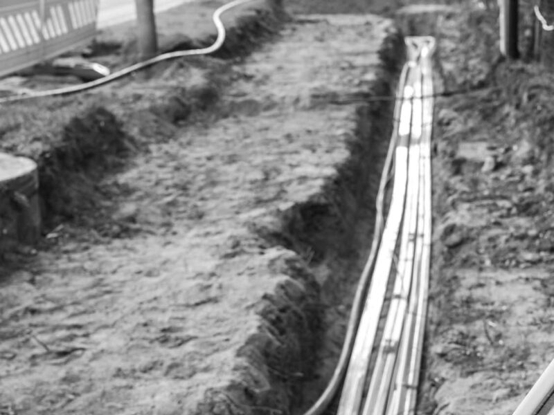 Construction site for installing fiber optic cables under the ground beside a street to bring fast internet to all residents, selected focus