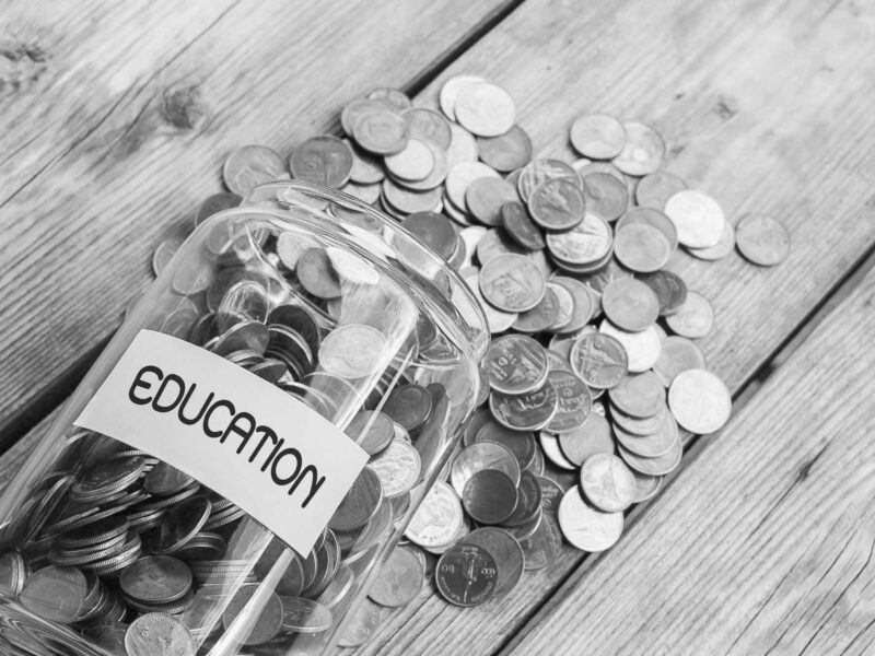 Money jar with coins on wood table , Saving for Education Concept