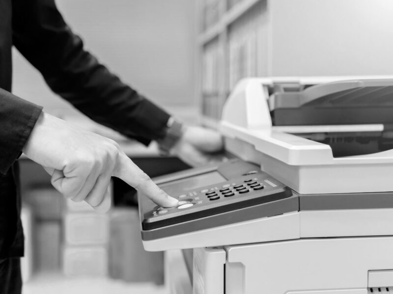 Close up bussiness man Hand press button on panel of printer, printer scanner laser office copy machine supplies start concept.