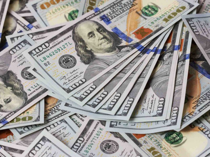 Hundred dollar bills stacked in a money pile