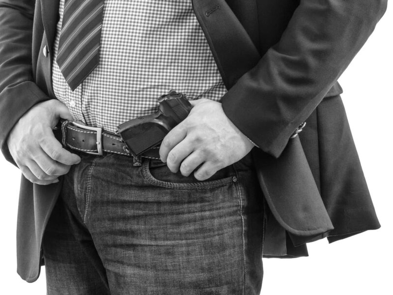 Man dressed business casual with gun in holster