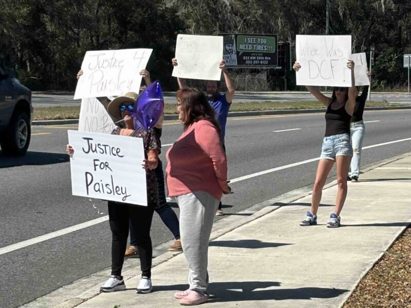 Demonstrators held signs to demand "Justice for Paisley," a 3-year-old toddler who died from abuse last week.