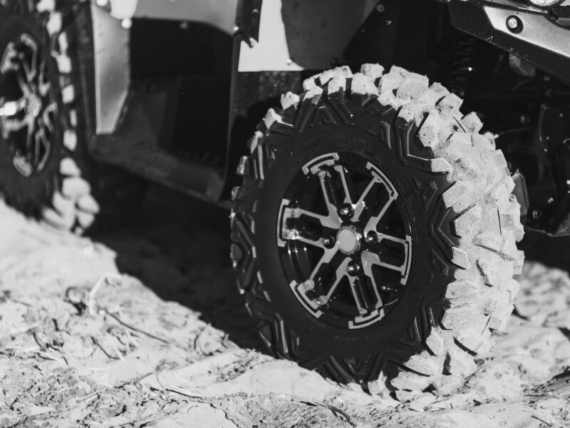 All terrain vehicle on dirt road in black and white