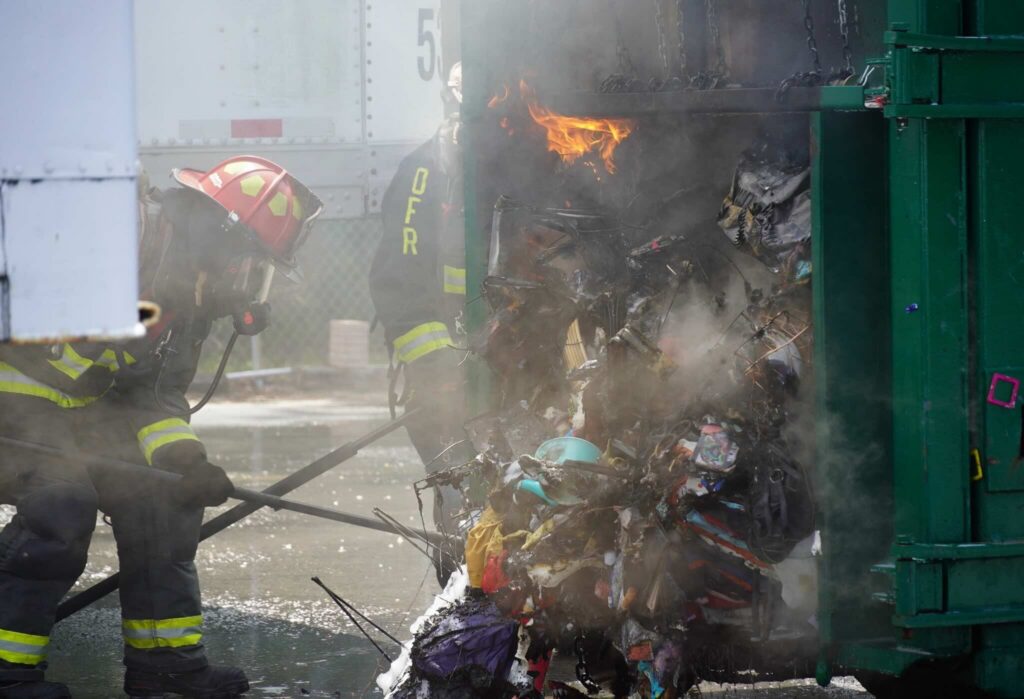 Garbage on fire within the commercial dumpster