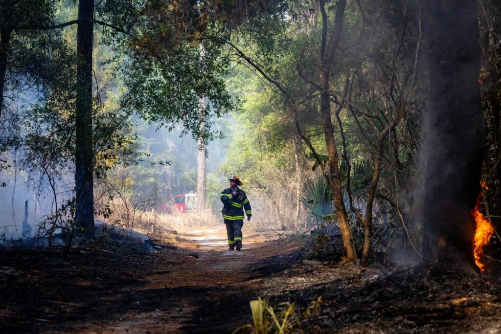 Marion County firefighter surveils the area that has been impacted by the fire